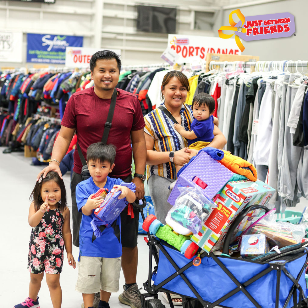 Mom holds daughter who is sleeping in her arms while she shops the local JBF sale.